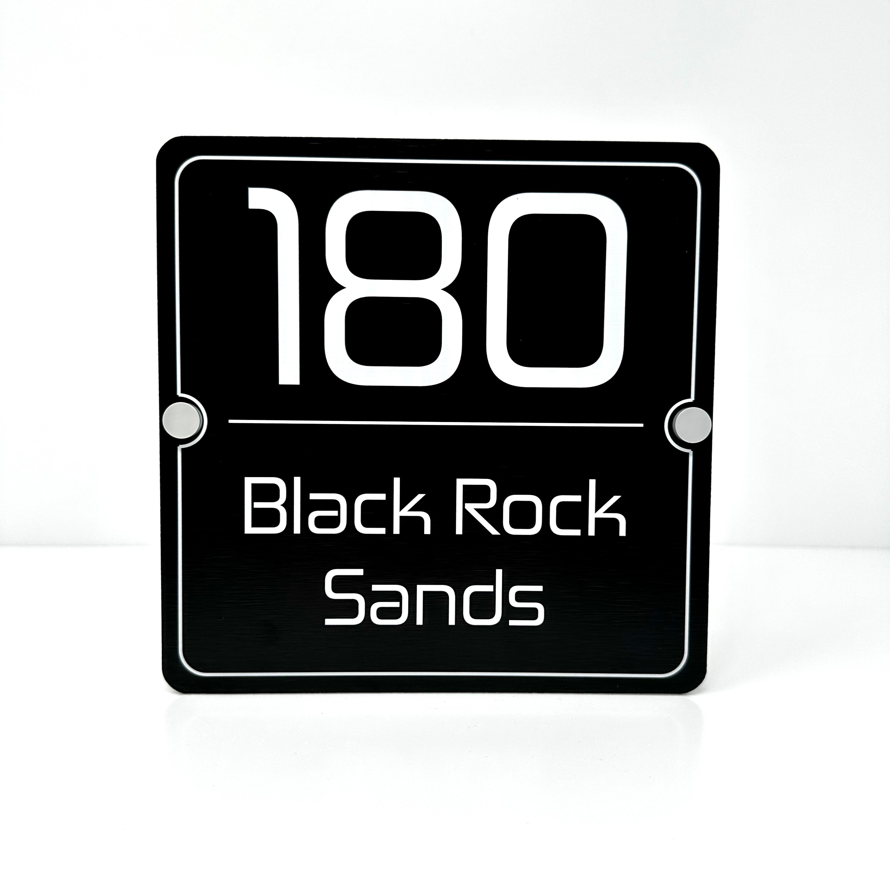 The Black Rock Sands Modern House Sign with a Brushed Black Panel and Satin Silver Stand Off Fixings ( Size - 20cm x 20cm )