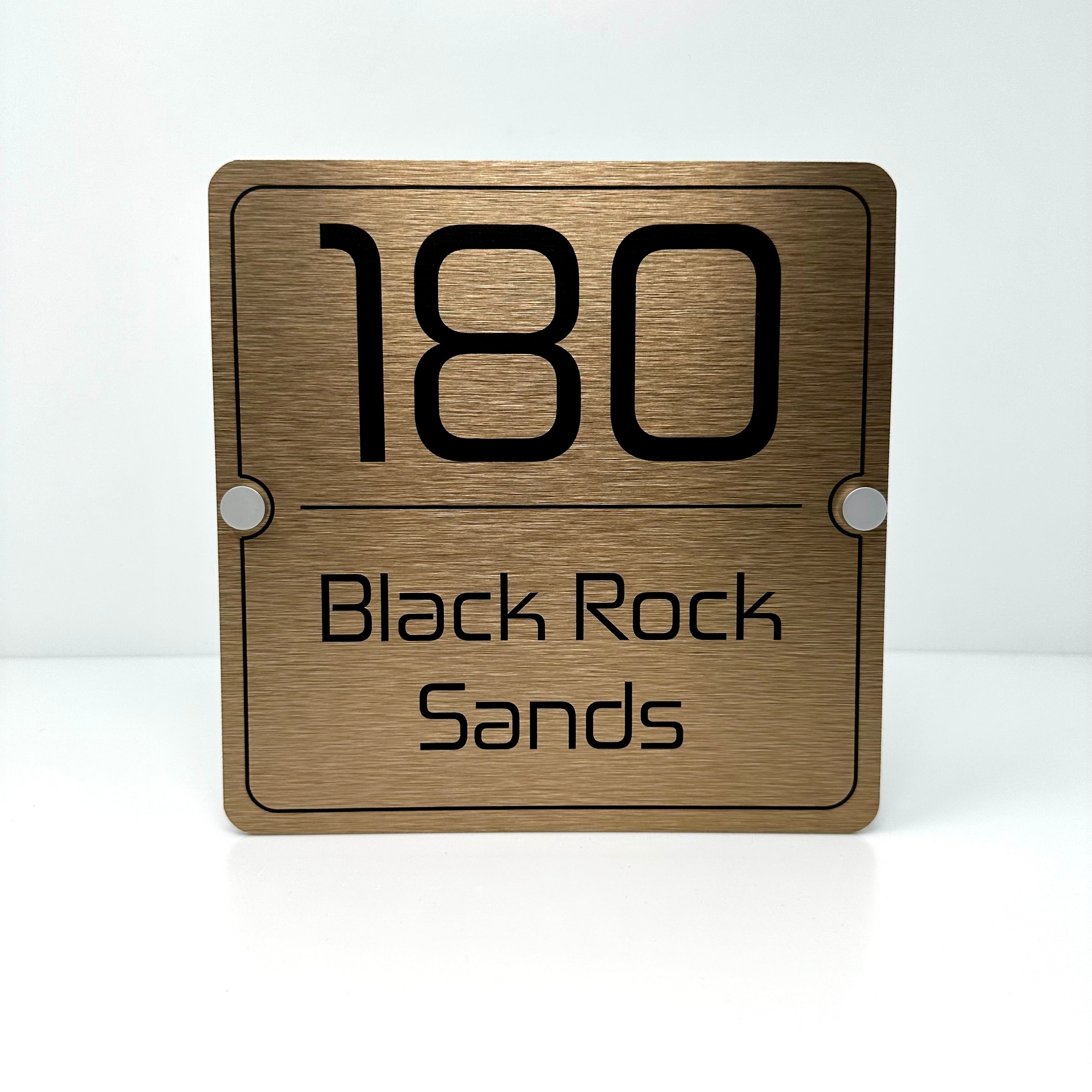 The Black Rock Sands Modern House Sign with a Brushed Brass Panel and Satin Silver Stand Off Fixings ( Size - 20cm x 20cm )