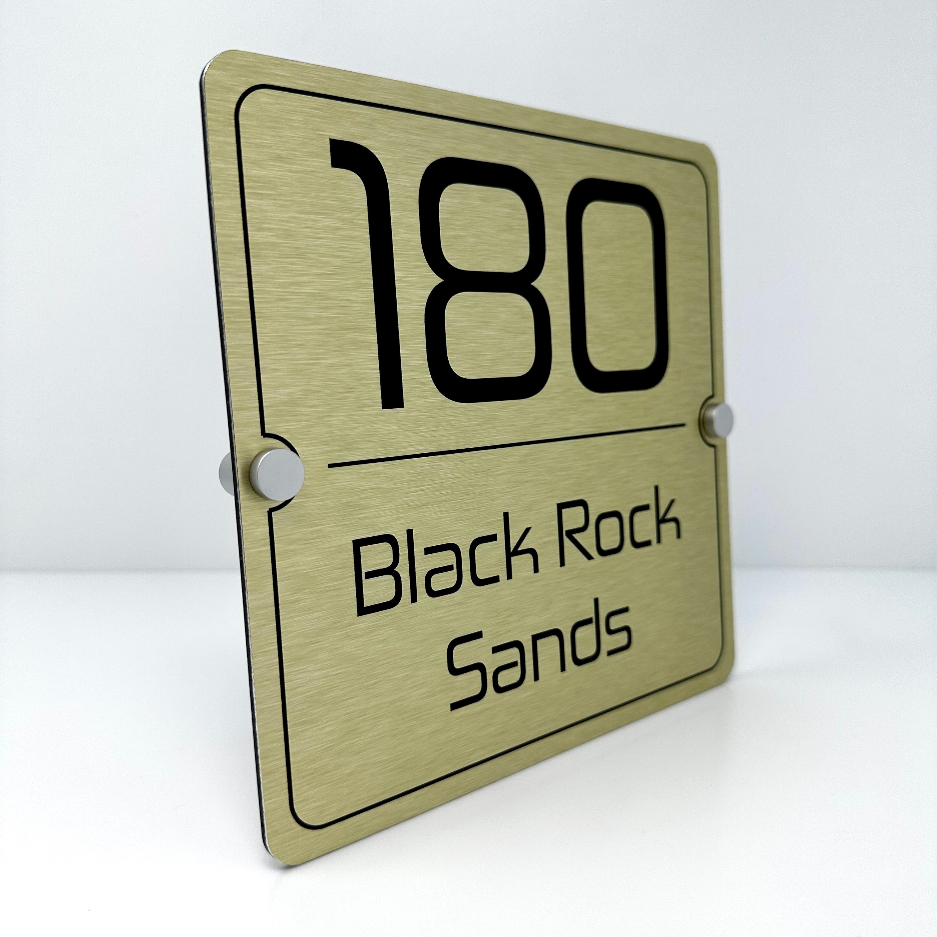 The Black Rock Sands Modern House Sign with a Brushed Gold Panel and Satin Silver Stand Off Fixings ( Size - 20cm x 20cm )