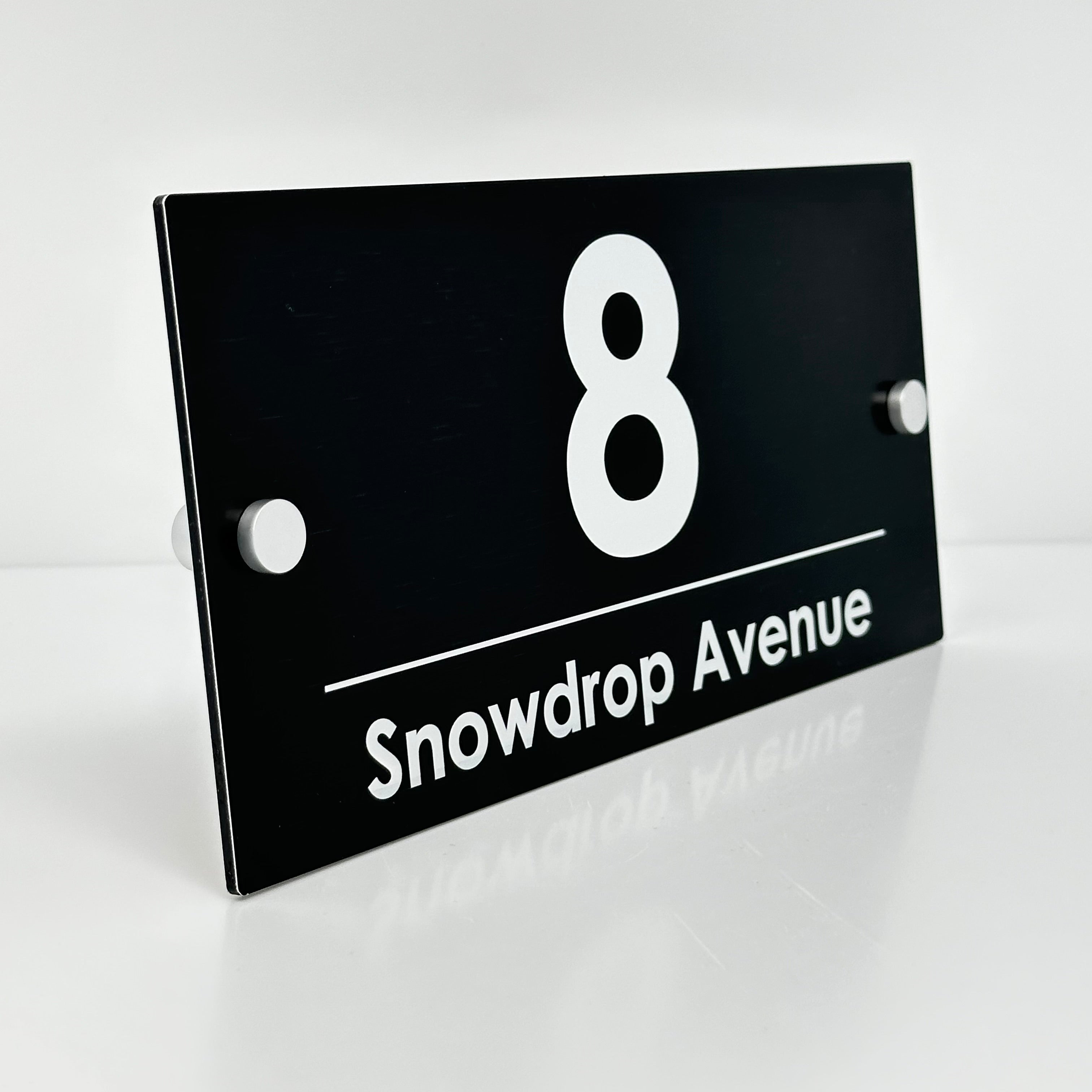 The Snowdrop Modern House Sign with a Brushed Black Panel and Satin Silver Stand Off Fixings ( Size - 25cm x 12cm )