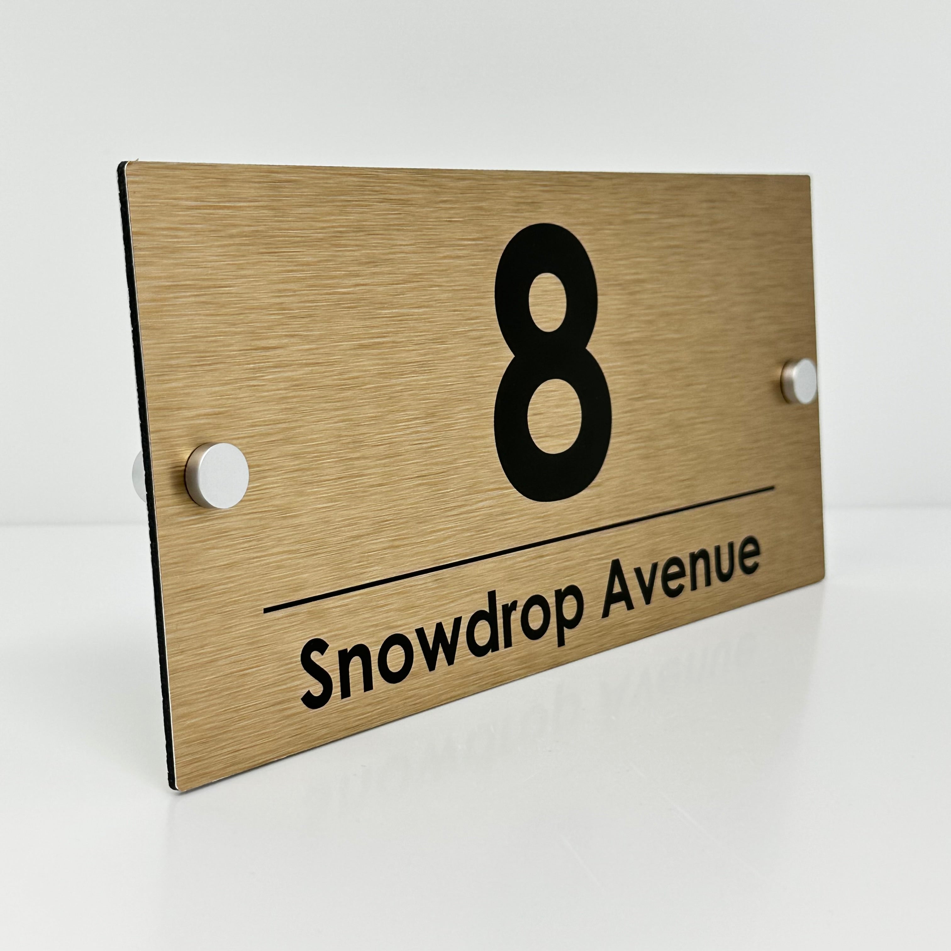 The Snowdrop Modern House Sign with a Brushed Brass Panel and Satin Silver Stand Off Fixings ( Size - 25cm x 12cm )